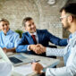 happy financial advisor male doctor shaking hands after successful meeting office 85x85